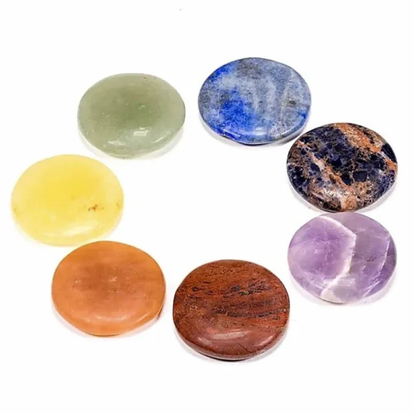 Chakra set van ronde, platte amuletten met de 7 chakra kleuren in zwart zakje